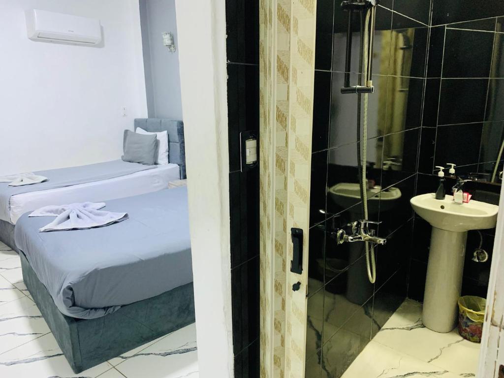 ein Badezimmer mit einem Bett, einer Dusche und einem Waschbecken in der Unterkunft Nada HOTEL in Kairo