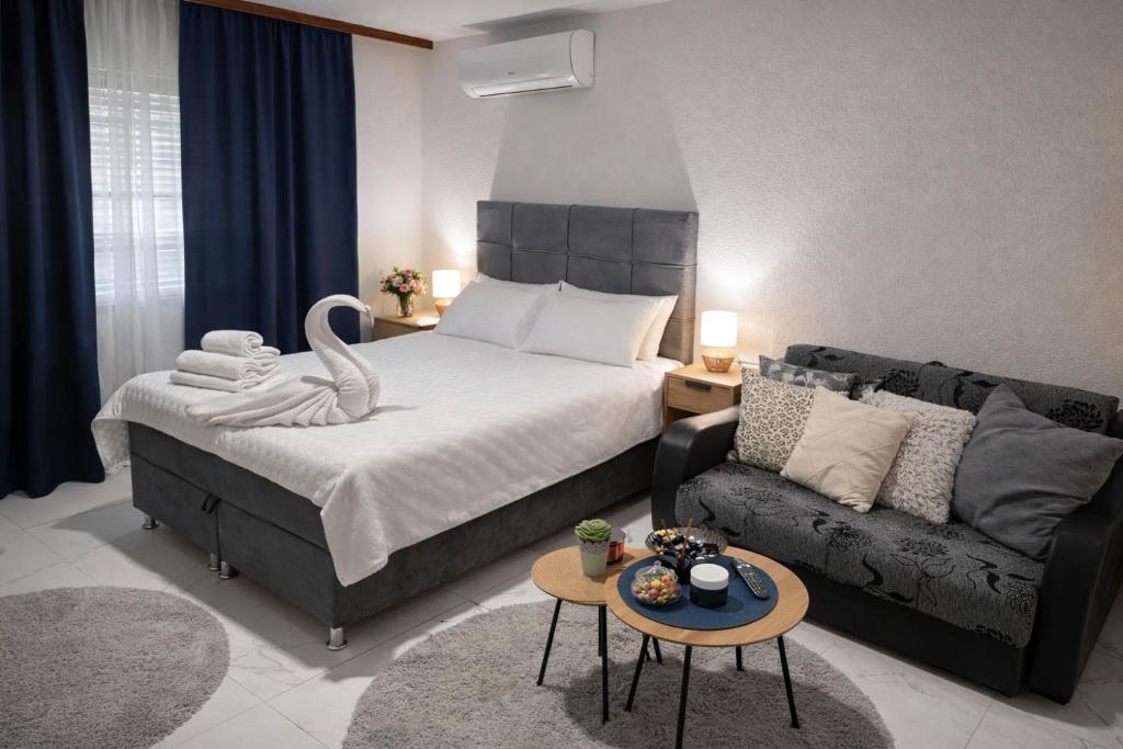 a bedroom with a large bed and a couch at Garden Lux Grujić Apartmani in Krivi Vir