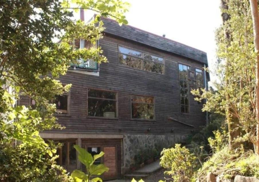 une maison en bois avec beaucoup de fenêtres dans l'établissement Refugio Kallfuko, a great space with nature, à Valdivia
