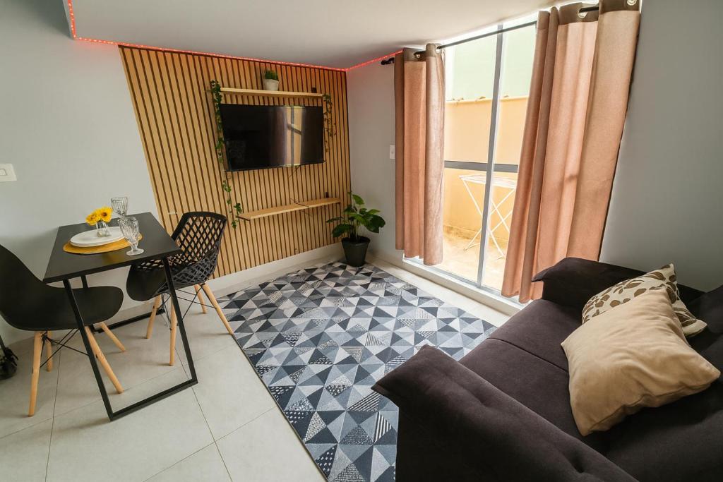 a living room with a couch and a table at Loft central perto da praia in Caraguatatuba