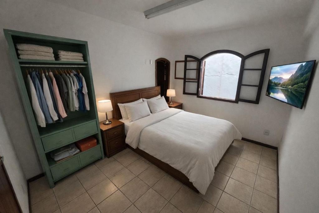 a bedroom with a bed and a window and a closet at L Grace Centro in Búzios