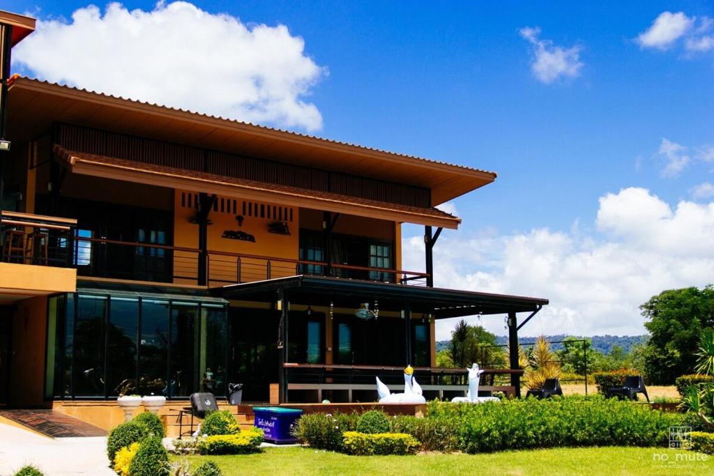a large house with a balcony and a yard at Sethachan Poolvilla Khaoyai in Ban Rai Khlong Sai