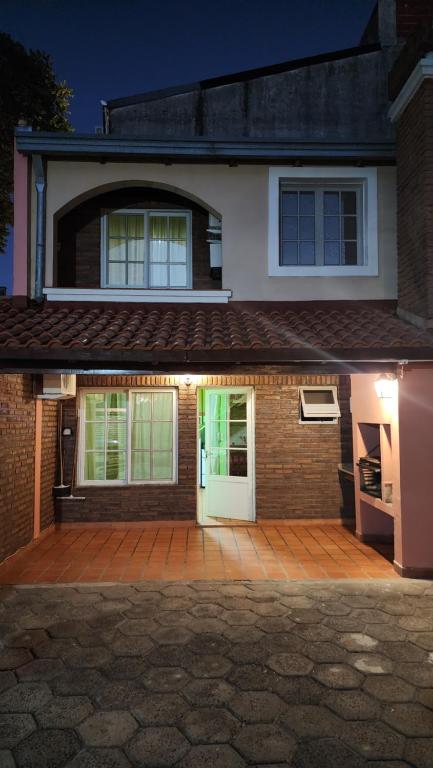 een huis met een witte deur en een patio bij Posada del Sol in Ituzaingó