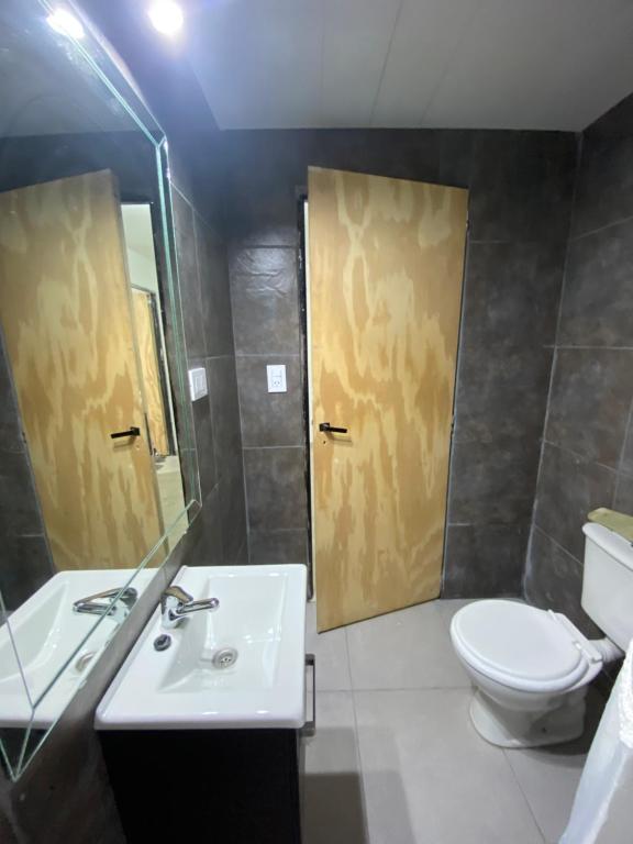 un bagno con un water, un lavandino e uno specchio di Quintas Baradero a Baradero