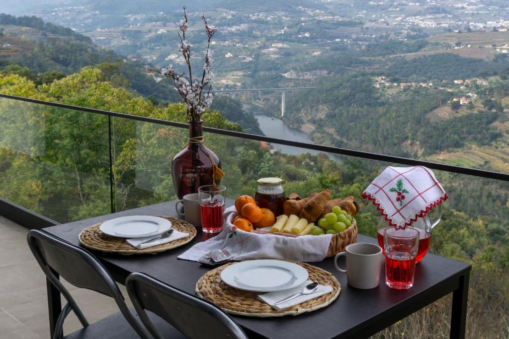 a table with a bowl of fruit and a basket of food at Cherry Douro Hill in Resende