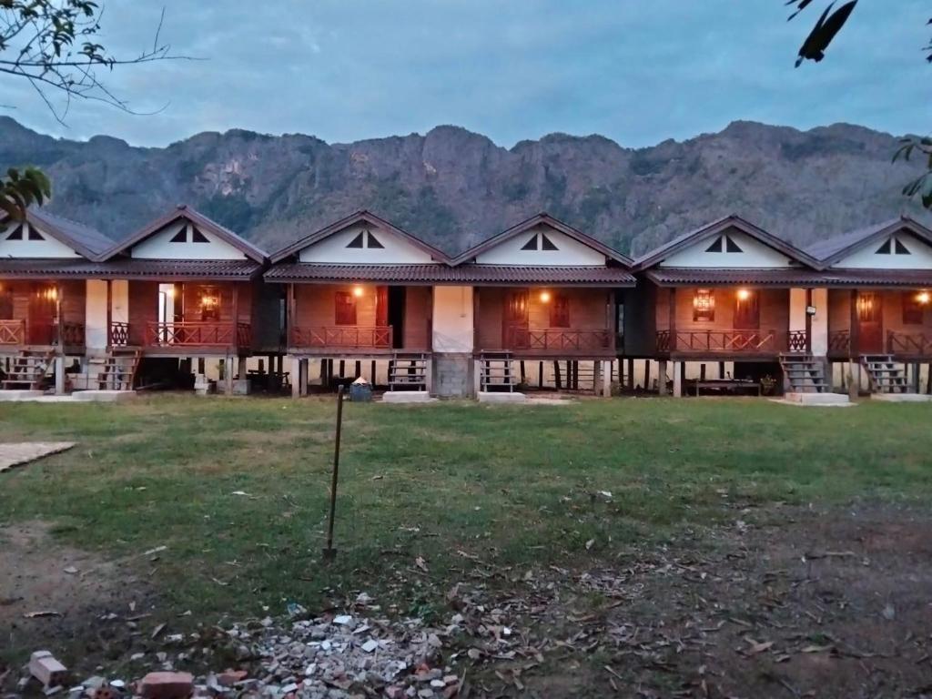 a row of houses with mountains in the background at Guesthouse and Restaurant SayLomYen KongLor in Ban Dôn