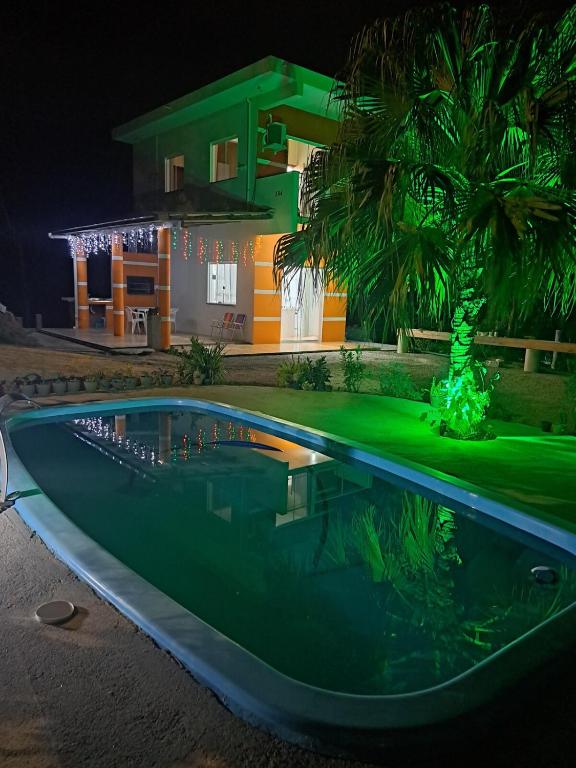 a swimming pool in front of a house at night at Sobradinho Morro dos Ventos in Palhoça