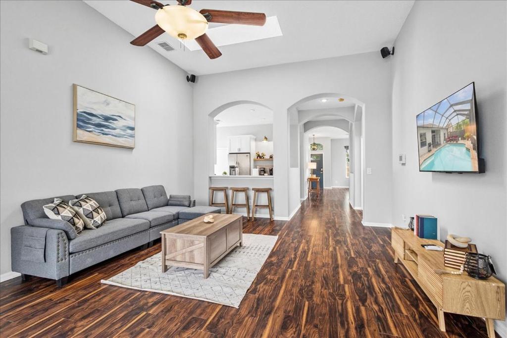 un soggiorno con un divano e un ventilatore a soffitto di NEW - Poolside Oasis Heated POOL Home - 2000 SF a Zephyrhills