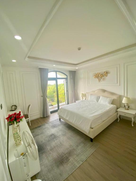 a bedroom with a large white bed and a window at UY LONG Homestay Grand World Phú Quốc in Phú Quốc