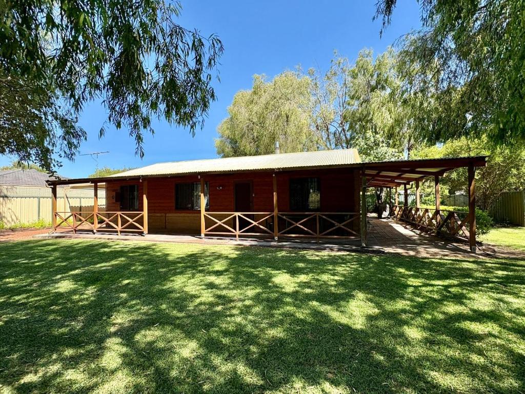 eine kleine Hütte mit einem Rasenplatz davor in der Unterkunft Macbeth Family Stay in Busselton