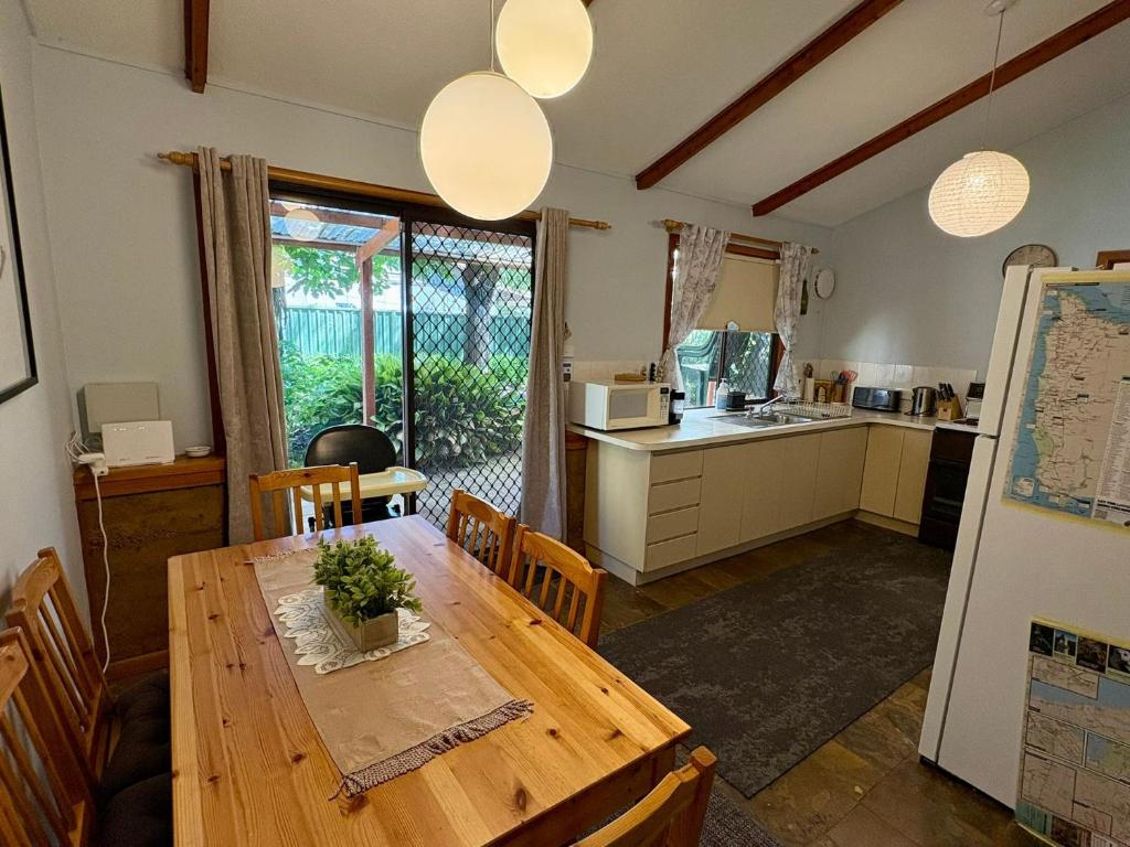 a kitchen and dining room with a wooden table at Macbeth Family Stay in Geographe