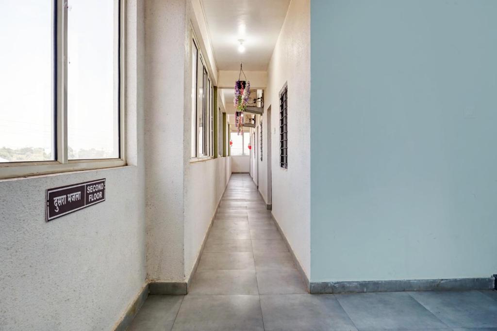 un corridoio in un edificio con finestre e lungo corridoio di Hotel O Royal Inn a Dehu