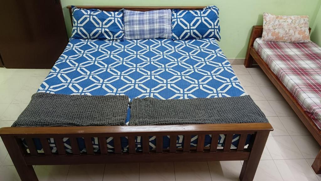 a bed with blue and white pillows on it at Cherry Blossom in Puducherry