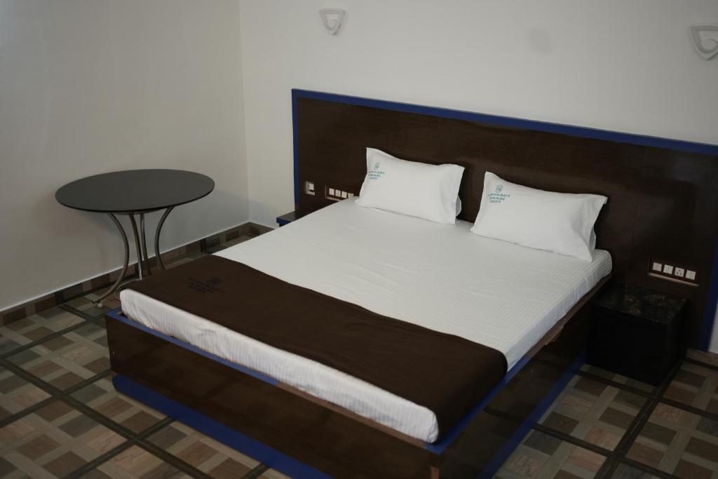 een bed in een kamer met een tafel ernaast bij Thekkady Arasi Hotel in Thekkady