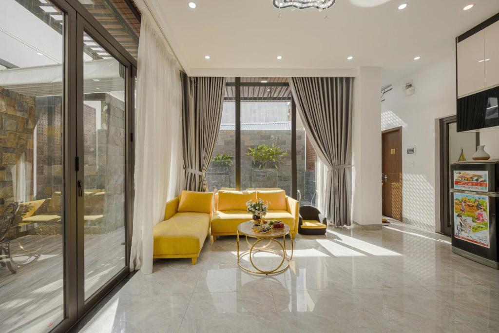 a living room with a yellow couch and a table at Villa's Võ Thị Sáu Huế in Hue