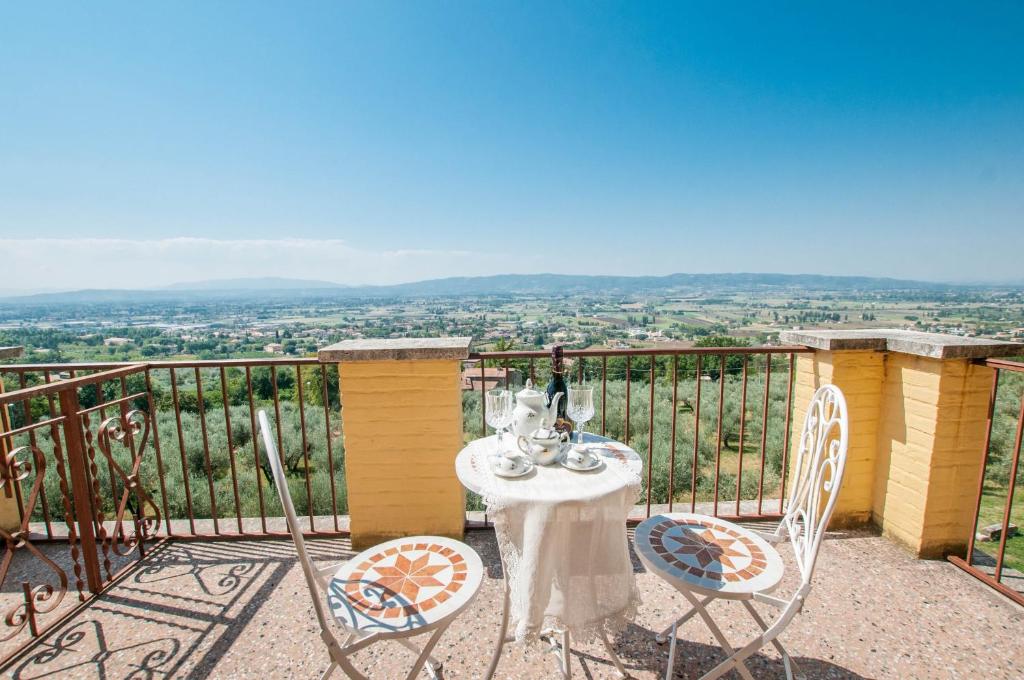einen Tisch und Stühle auf einem Balkon mit Aussicht in der Unterkunft Agriturismo Villa Val D'Olivi in Capodacqua