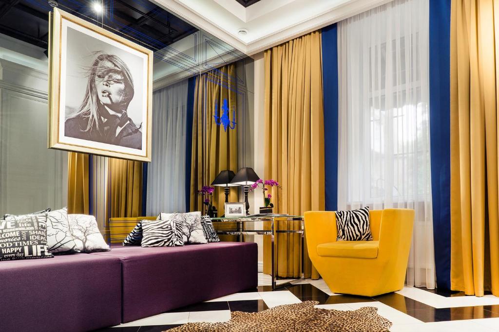 Mirax Sapphire Boutique Hotel في خاركوف: غرفة معيشة مع أريكة أرجوانية وكرسي أصفر