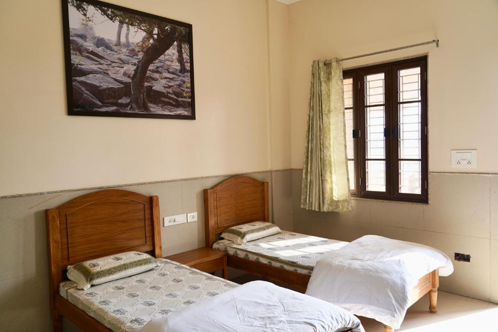 Postel nebo postele na pokoji v ubytování Iskcon Govardhan Retreat Center