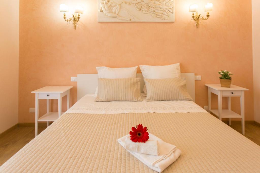 ローマにあるAmedeo Apartmentのベッドルーム1室(赤い花のベッド1台付)