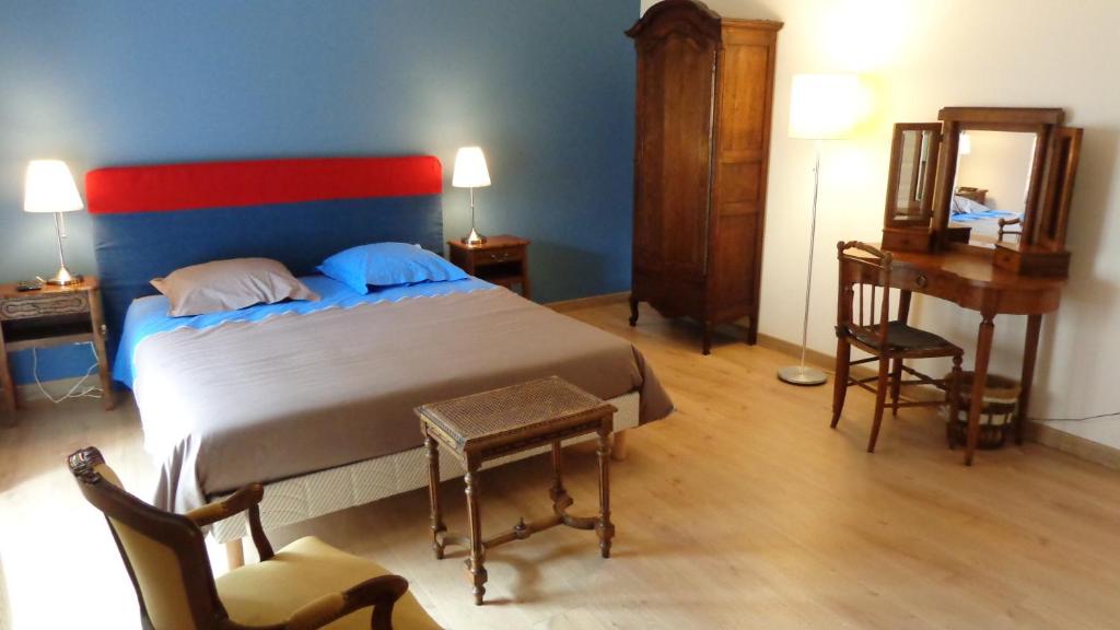 Athis的住宿－Au clos des colombages，一间卧室配有一张床、一张书桌和一面镜子