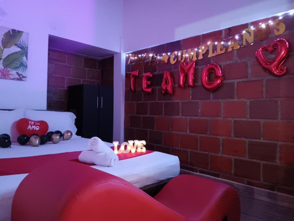 Ein Zimmer mit zwei Betten und einer Backsteinwand mit einem Schild in der Unterkunft Hotel Colinas Del Darien in Calima