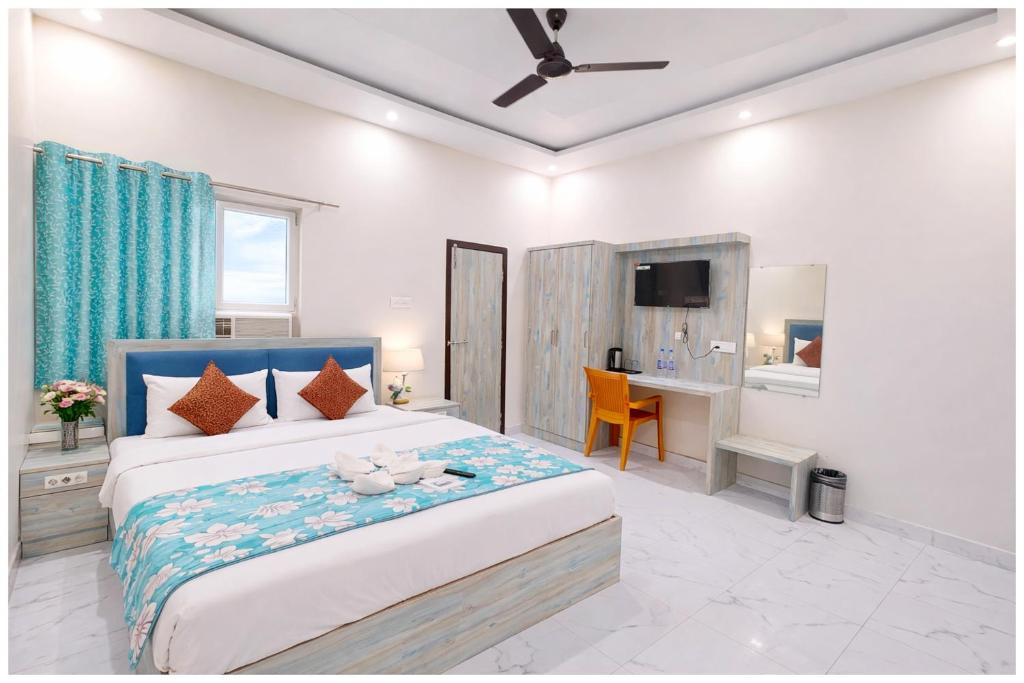 een slaapkamer met een groot bed en een bureau bij Vrinda Home-Stay Near Vishwanath Temple - Free Wifi and Free Parking Facilities # Free Wifi Facilities # Fully Air conditioning Luxuary Room - Top Rated Hotel In Varanasi in Varanasi