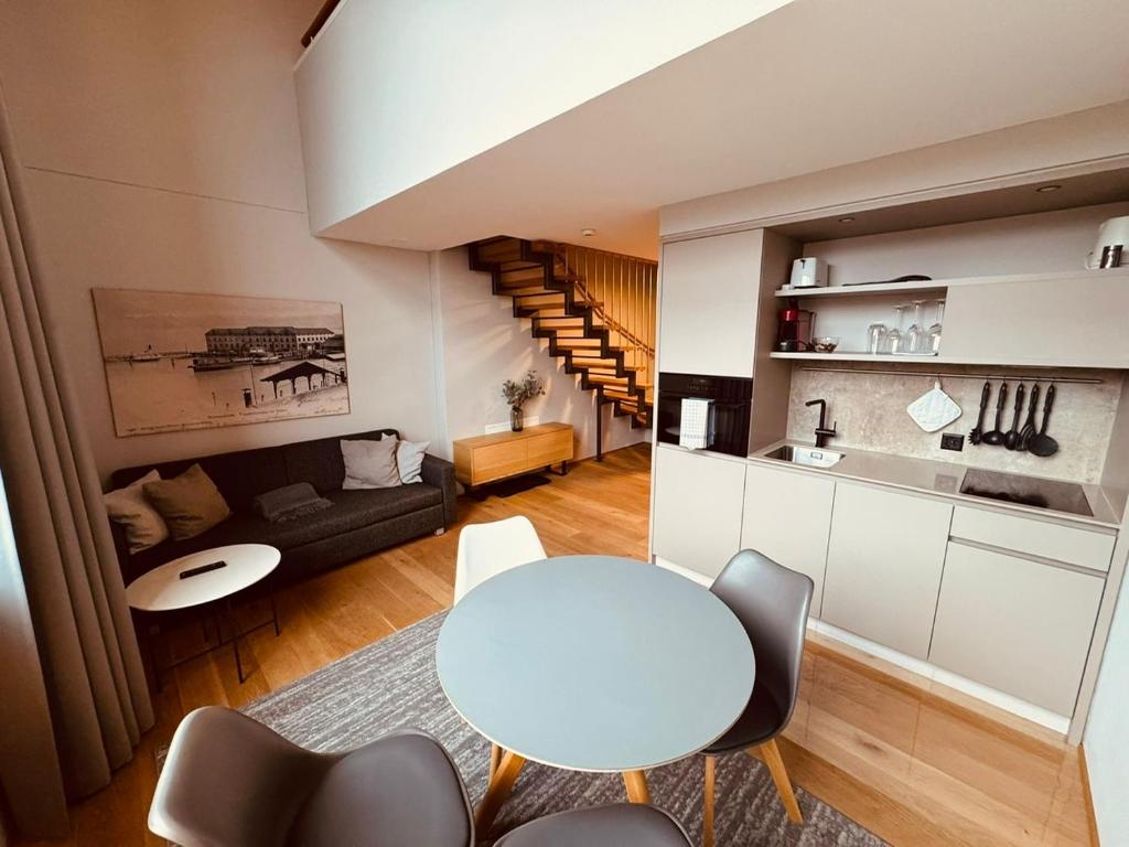 une cuisine et un salon avec une table et des chaises blanches dans l'établissement LAKE-SIDE Säntisblick, à Romanshorn