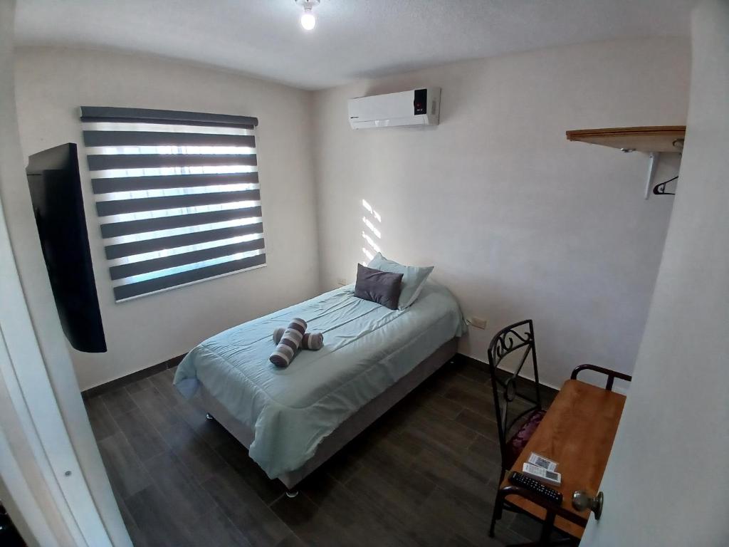 Schlafzimmer mit einem Bett, einem TV und einem Fenster in der Unterkunft Vivienda completa 2 plantas, y privada con acceso controlado in Hermosillo