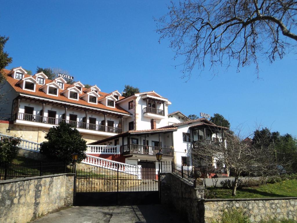 un gran edificio blanco con una valla delante en Hotel Solatorre, en Comillas