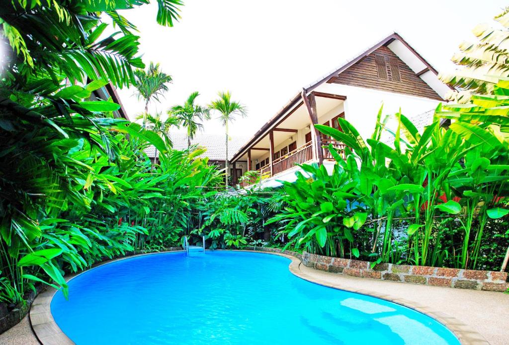 a large blue swimming pool in front of a building at Shewe Wana Boutique Hotel in Chiang Mai