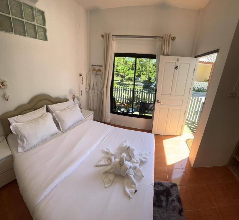 a bedroom with a white bed with a teddy bear on it at Yada House Alina Cottage in Nai Yang Beach