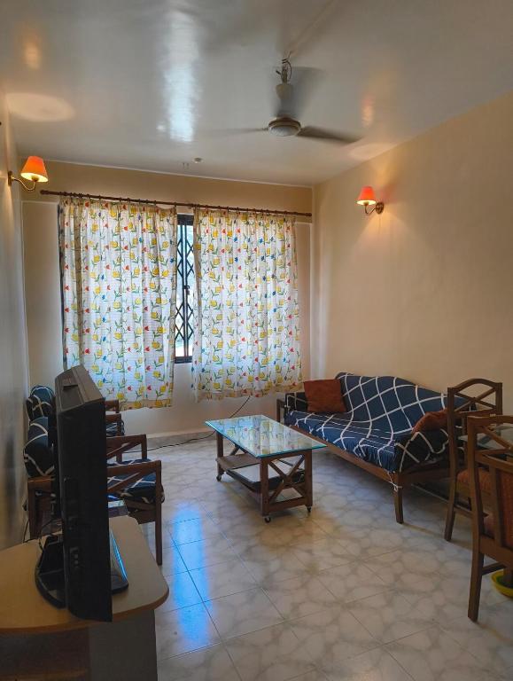 ein Wohnzimmer mit Sofa und Tisch in der Unterkunft Casa de Sim in Benaulim