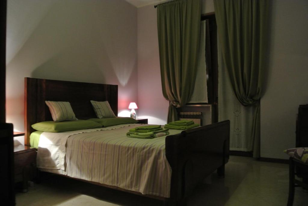 トリノにあるAppartamento Borgo Auroraのベッドルーム1室(緑の枕が付いたベッド1台付)
