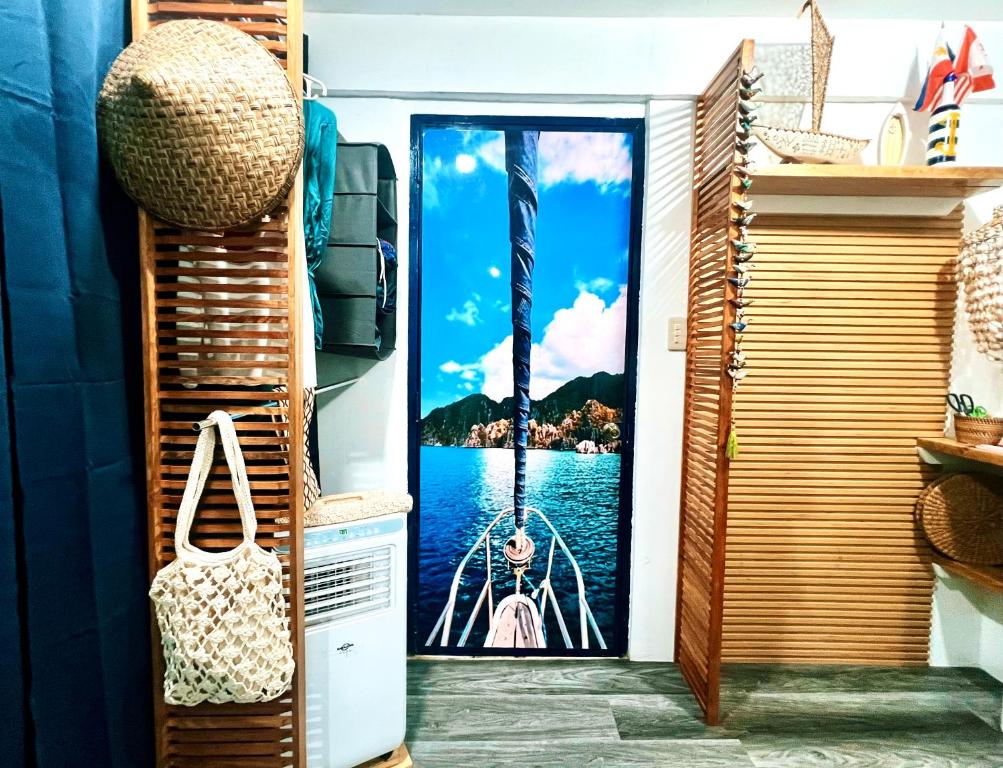 a door with a picture of a woman on the water at Kasa Gigi in El Nido
