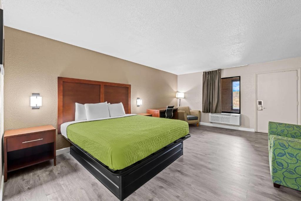 a hotel room with a bed with a green bedspread at Econo Lodge Kannapolis - Concord in Kannapolis