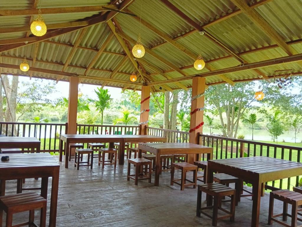 een groep tafels en stoelen in een paviljoen bij Canal Side Safari Resort in Udawalawe