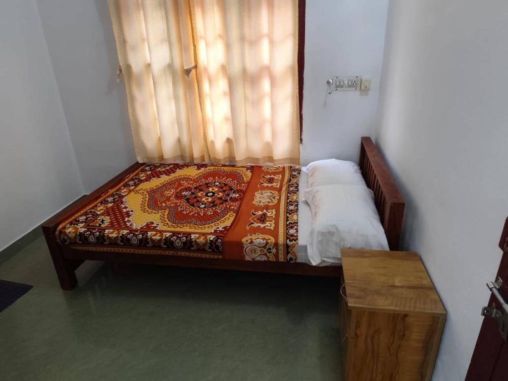 a small bed in a room with a window at Agapi Homestay in Cochin