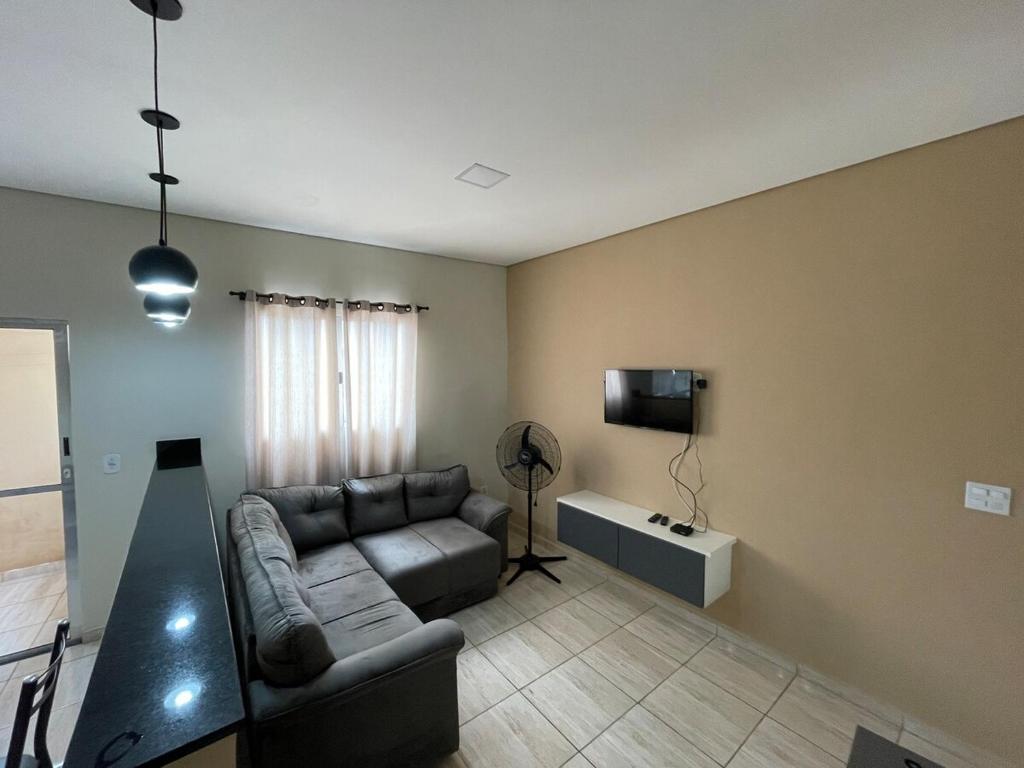 een woonkamer met een bank en een tv bij Casa de alto padrão in Aparecida