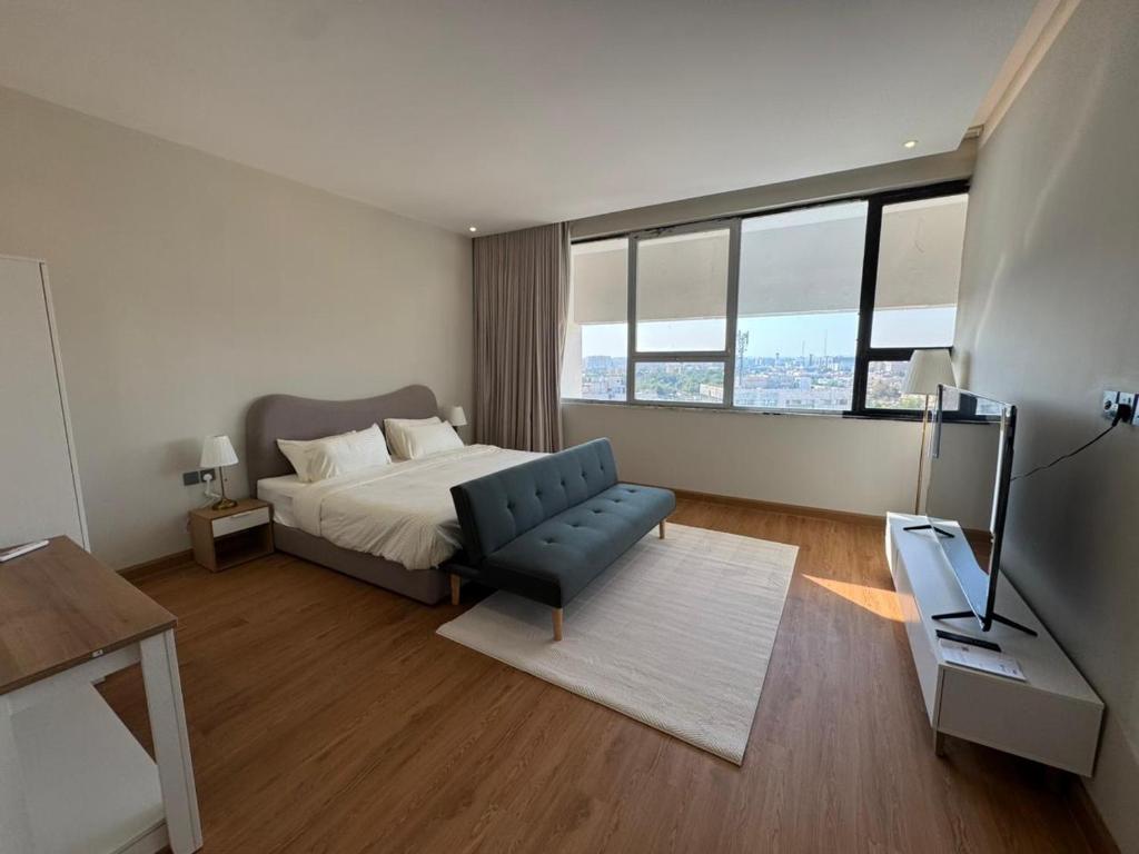 a bedroom with a bed and a chair and window at سكينة هاوس in Riyadh