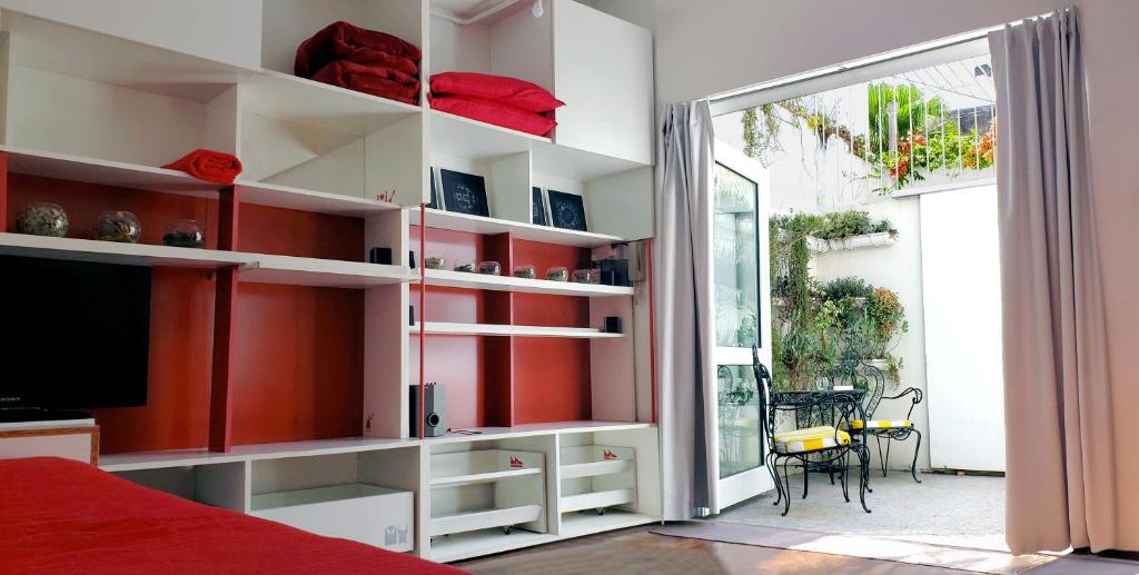 a bedroom with white shelves and a sliding glass door at Dos Patios - Luz, tranquilidad y verde in La Plata