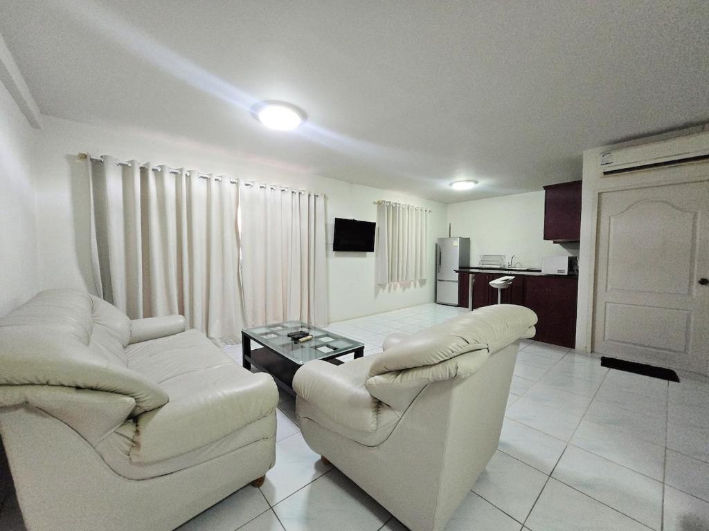 a living room with two chairs and a coffee table at Townhome 49 in Ban Nong Pru