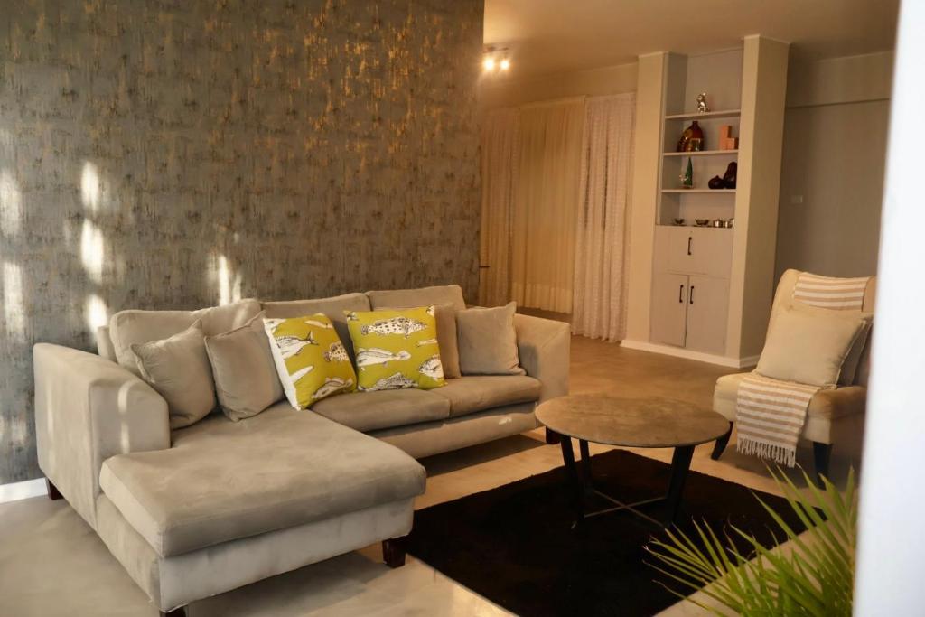 ein Wohnzimmer mit Sofa und Tisch in der Unterkunft San Remo on Windermere Rd. Humewood Beachfront in Gqeberha