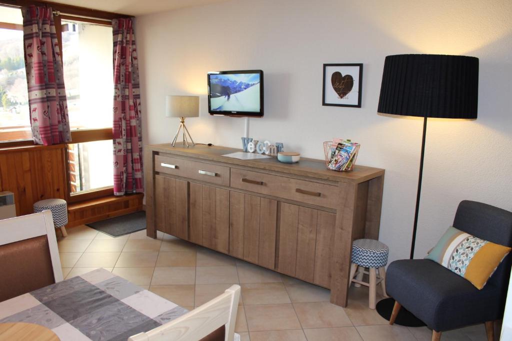 a living room with a tv and a chair at Cosylocation Super Besse in Besse-et-Saint-Anastaise