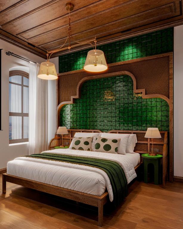 a bedroom with a large bed with a green headboard at Castellion Hotels Galata in Istanbul