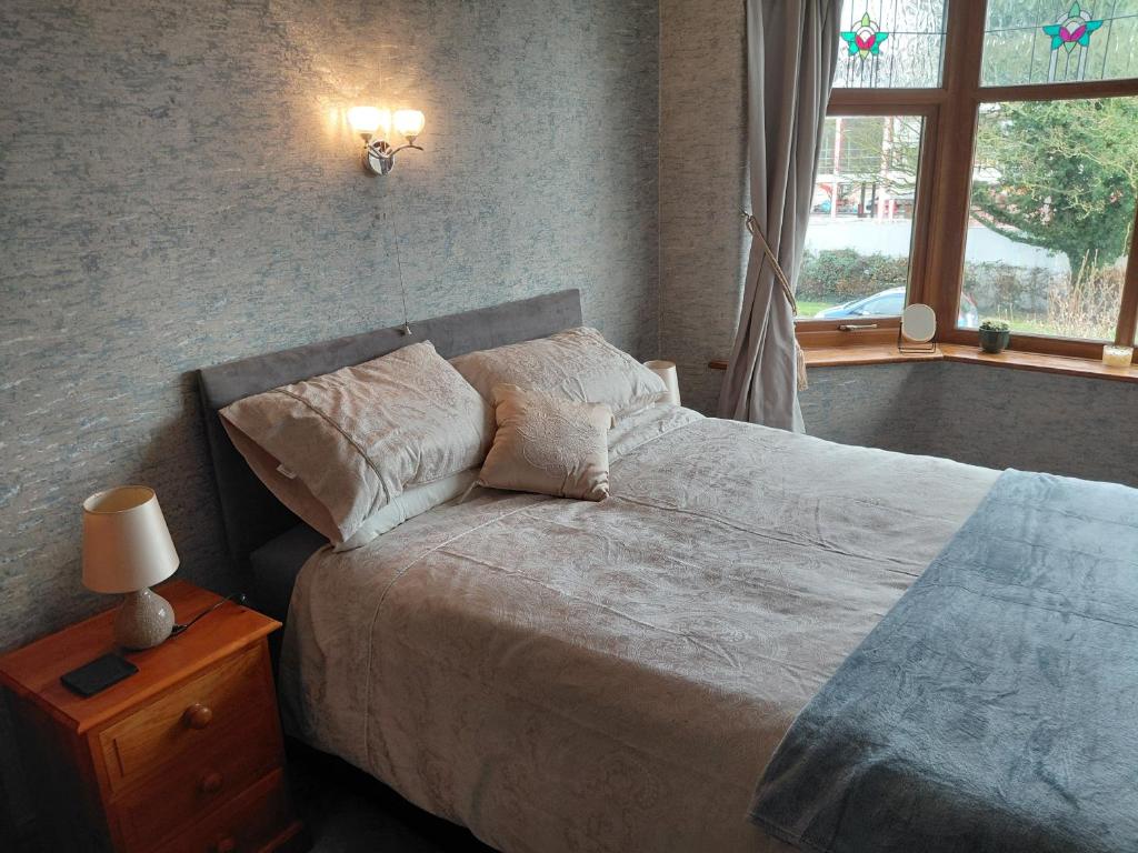 ein Schlafzimmer mit einem Bett mit Kissen und einem Fenster in der Unterkunft Penwortham traditional home in Penwortham