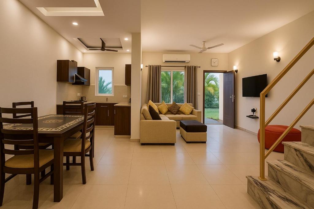 een woonkamer en keuken met een tafel en een bank bij The Ruby Resort Vrindavan # Prime Location # Luxury Rooms # Near Prem Mandir # Restaurant # Big Lawn # Big Parking # By Nandan Group # in Vrindāvan