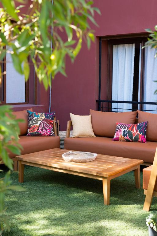a coffee table in front of a couch with pillows at Accès direct piscine - appartement avec jardin in Marrakesh