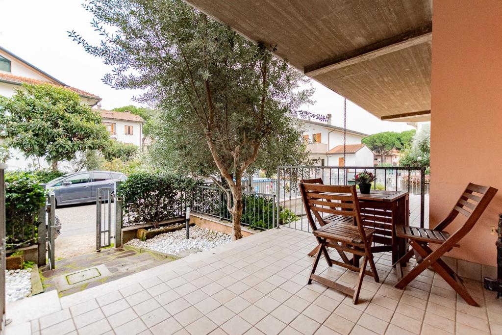 een patio met 2 stoelen, een tafel en een boom bij Trilocale con giardino a Cervia - CV012 in Cervia