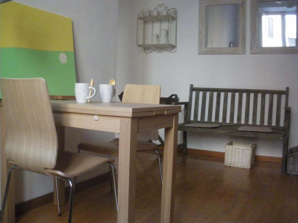 a wooden table with chairs and a bench in a room at Casa Castelbolognese in Rome