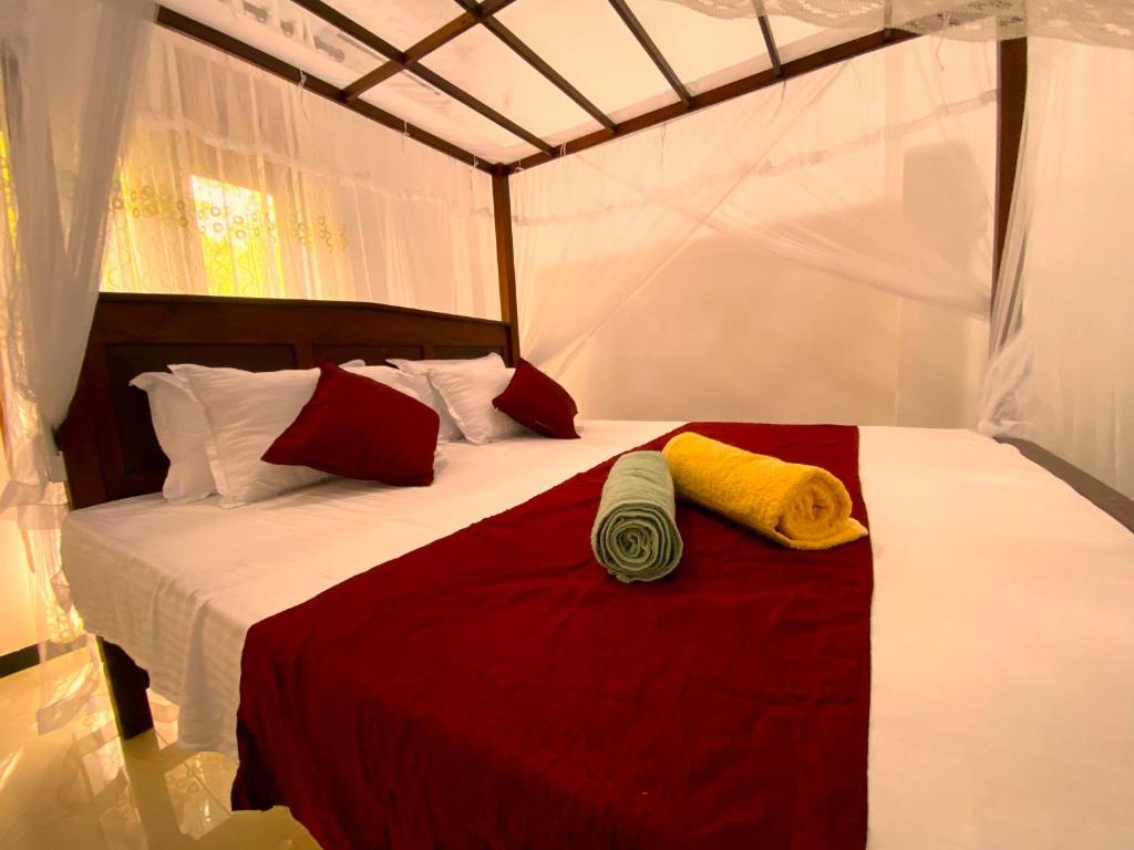 a bed in a tent with two towels on it at Green Calm Villa in Kamburugamuwa